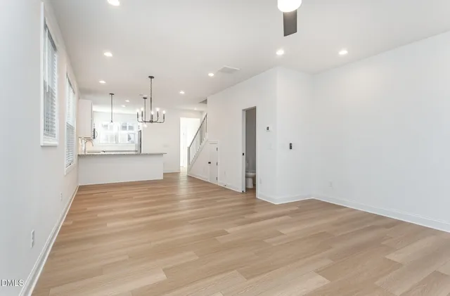 a kitchen with kitchen island a wooden floor and a chandelier