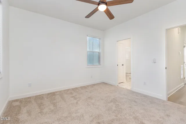 a view of an empty room and a ceiling fan