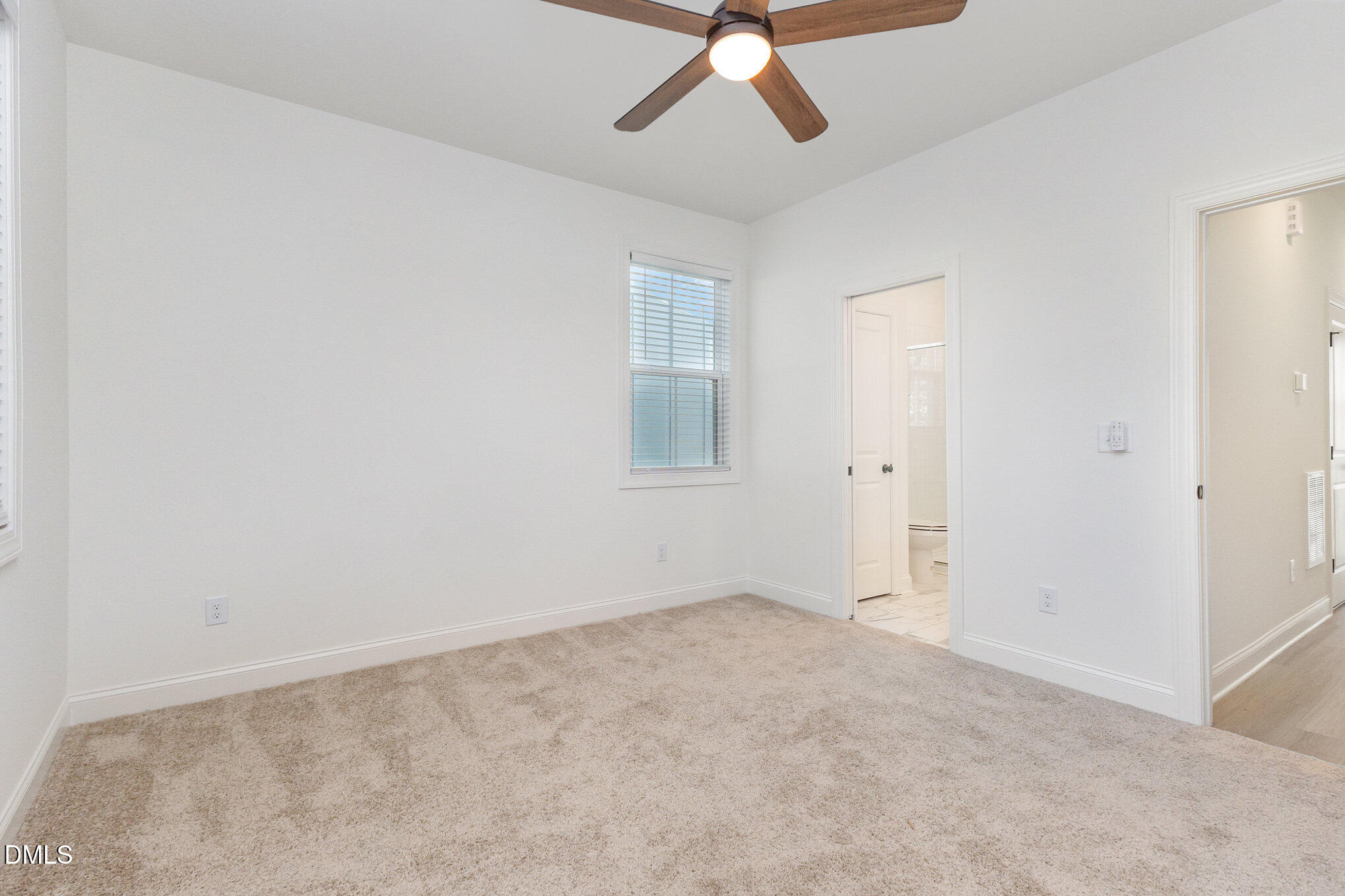 4801 Gossamer Lane, Unit 106 Raleigh, NC 27616 - Photo 32 of 42 an empty room with a chandelier fan and windows