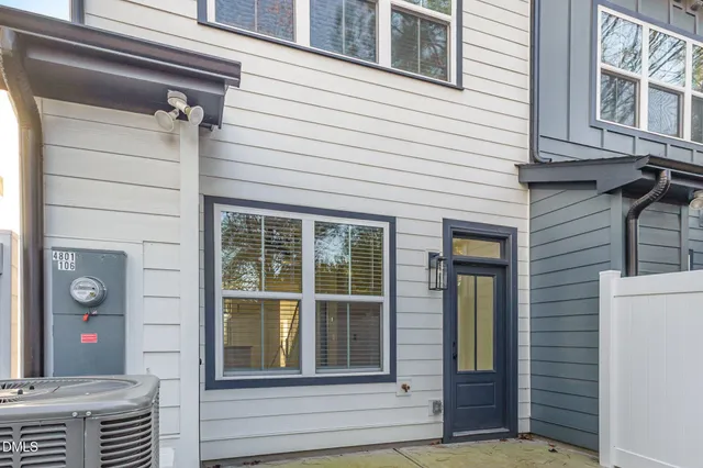 an empty room with a chandelier fan and windows