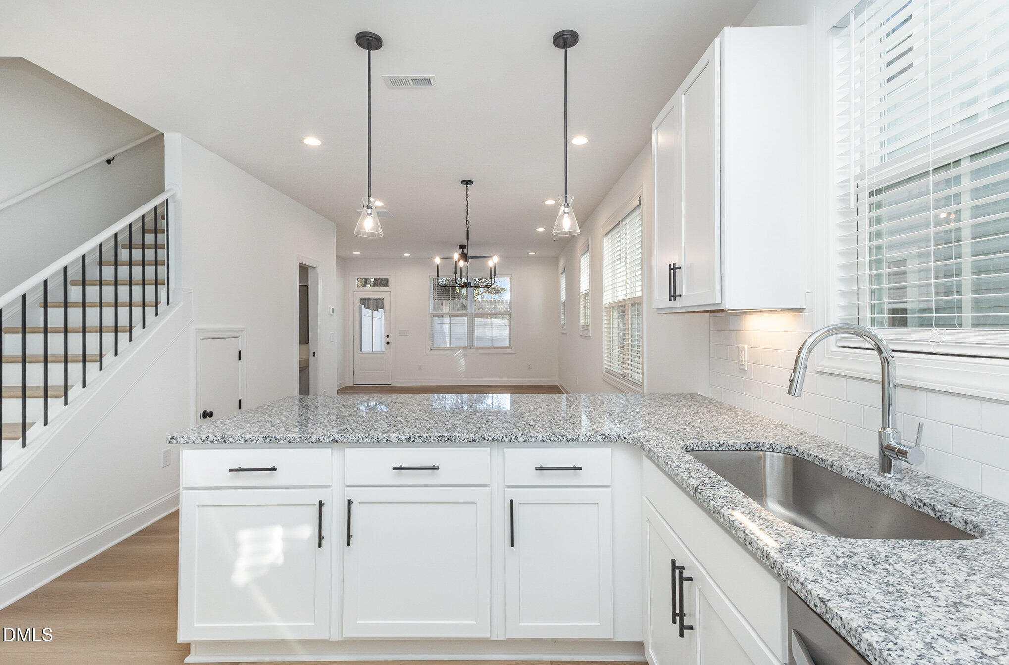 4801 Gossamer Lane, Unit 106 Raleigh, NC 27616 - Photo 6 of 42 a kitchen with kitchen island granite countertop a sink a counter space appliances and cabinets