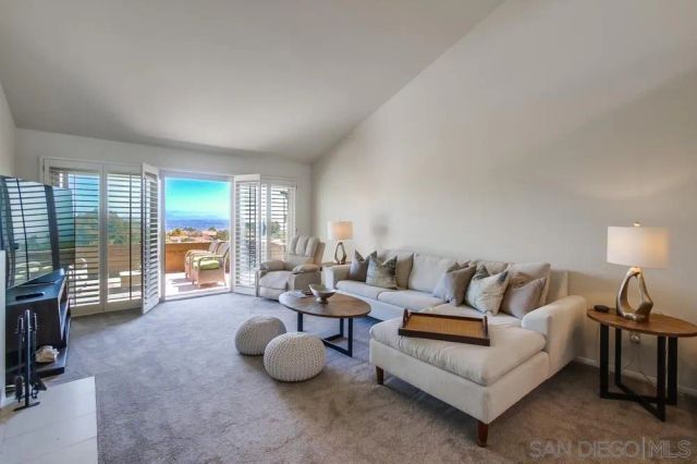 a living room with furniture a fireplace and a large window