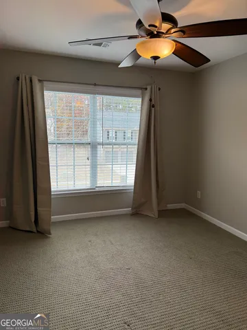 a view of room with a ceiling fan and a window