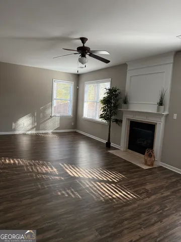 a view of empty room with wooden floor and fireplace