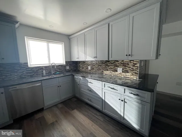 a kitchen with stainless steel appliances a refrigerator sink and white cabinets