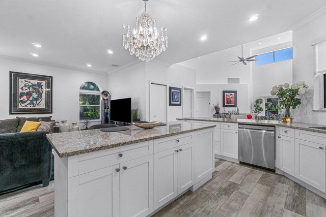 a spacious kitchen with a granite countertop sink and a large mirror