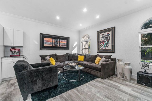 a living room with furniture a couch a dining table and paintings on the wall