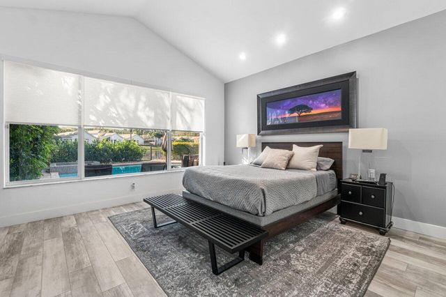 a bedroom with a bed and a large window