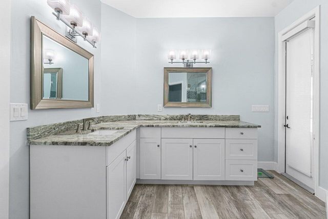 a bathroom with a granite countertop sink and a mirror