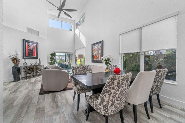 a dining room with furniture a chandelier and wooden floor