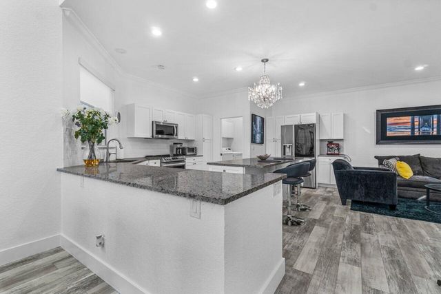 a kitchen with granite countertop a sink stove and cabinets