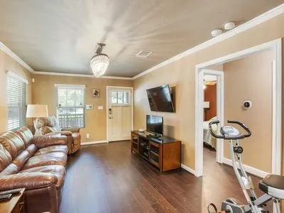 a living room with furniture a flat screen tv and wooden floor