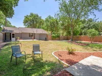 a view of a house with backyard and sitting area