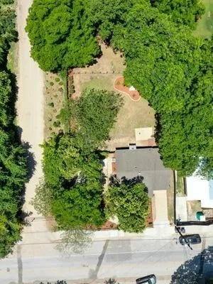 an aerial view of a house with a yard and large trees