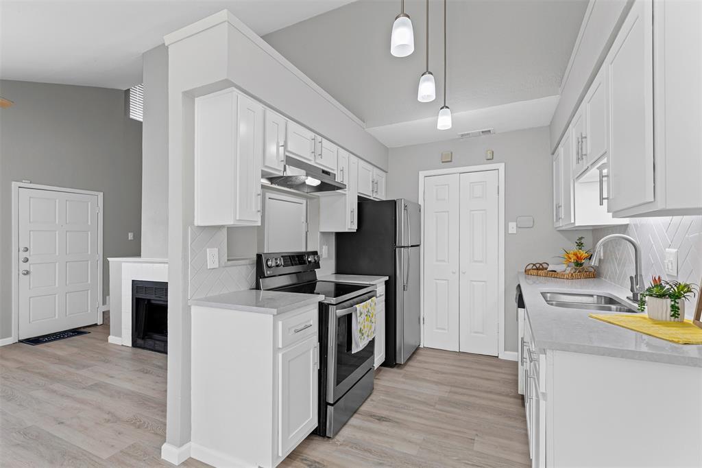 2240 Tarpley Road, Unit 422 Carrollton, TX 75006 - Photo 1 of 1 a kitchen with stainless steel appliances granite countertop a refrigerator a stove a sink dishwasher and white cabinets with wooden floor