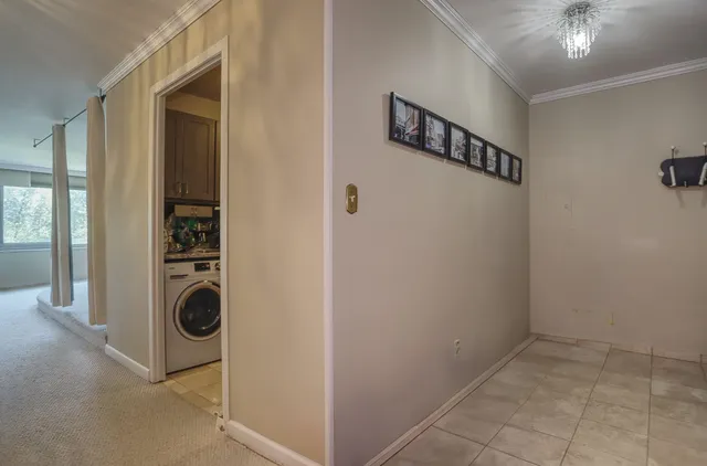 a view of a hallway with closet and a window