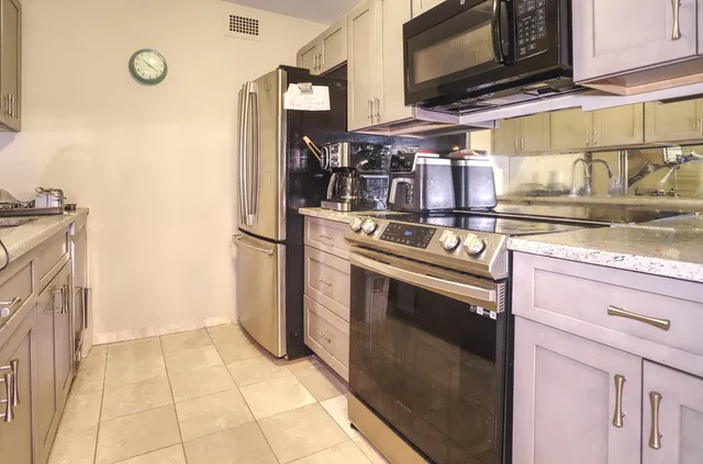 a kitchen with stainless steel appliances granite countertop a stove and a refrigerator