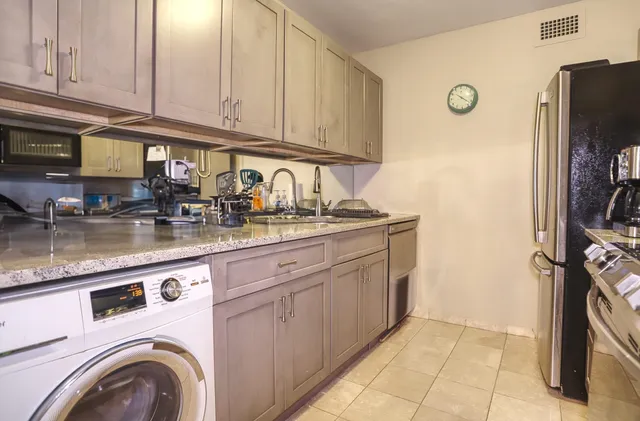 a kitchen with stainless steel appliances granite countertop a refrigerator and cabinets