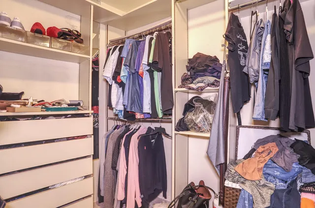 a view of walk in closet with clothes and shoes