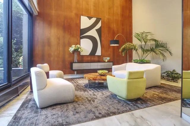 a living room with furniture and a painting on the wall