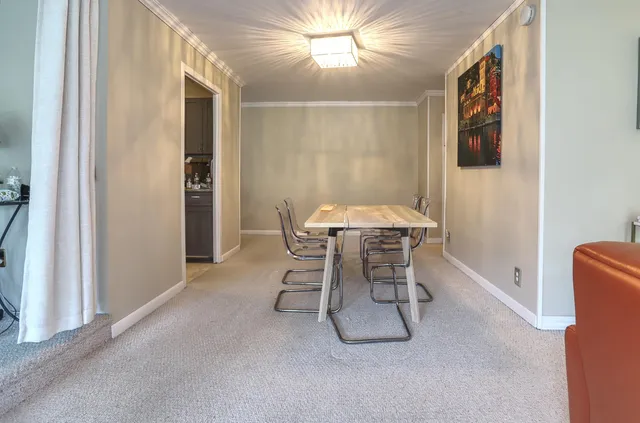 a dining room with furniture and chandelier fan