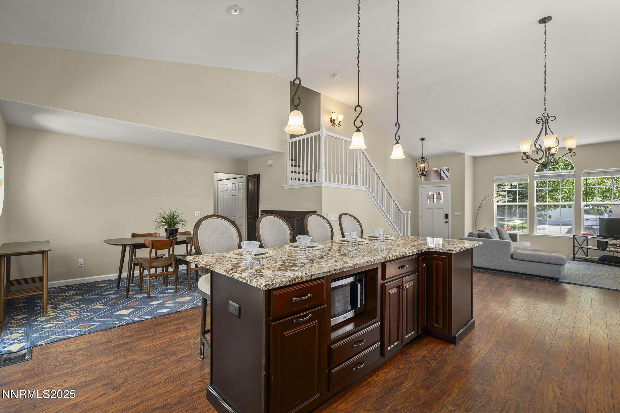 9783 Northrup Drive Reno, NV 89521 - Photo 15 of 39 a open kitchen with stainless steel appliances granite countertop a stove a sink a dining table chairs and chandelier