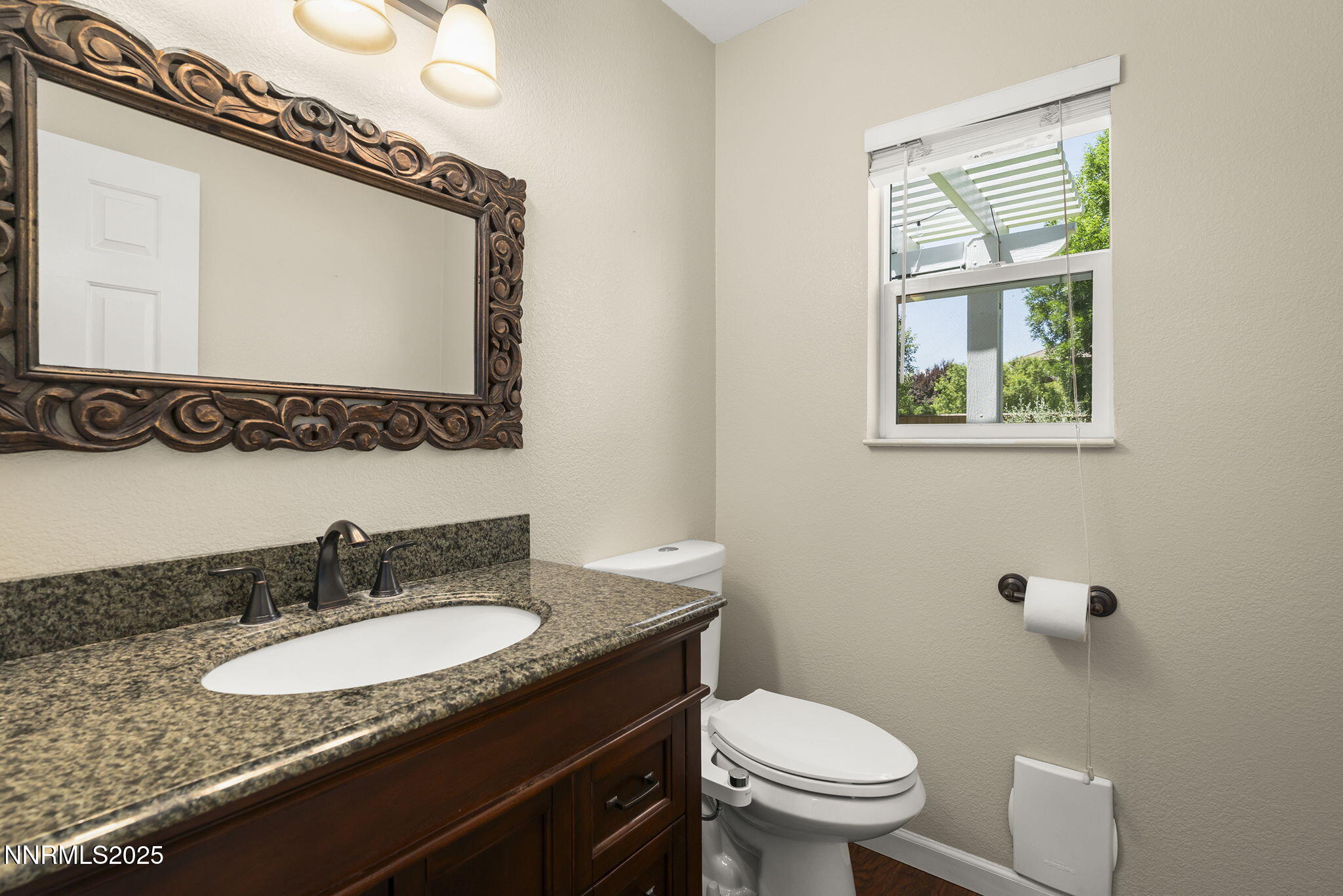 9783 Northrup Drive Reno, NV 89521 - Photo 18 of 39 a bathroom with a granite countertop toilet a sink and mirror