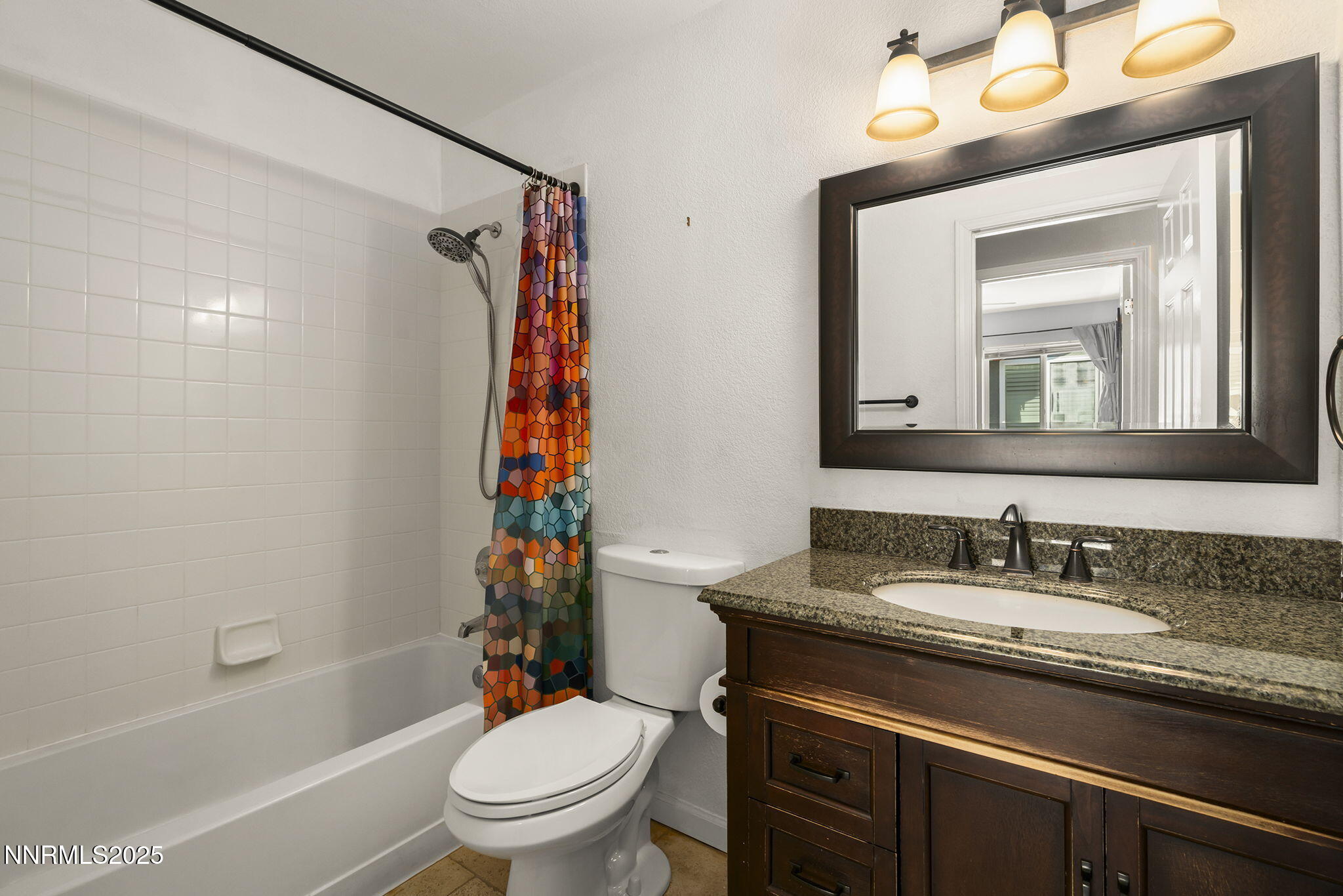 9783 Northrup Drive Reno, NV 89521 - Photo 23 of 39 a bathroom with a granite countertop sink toilet a mirror and shower