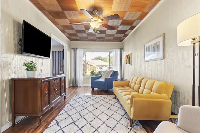 a living room with furniture a flat screen tv and a chandelier
