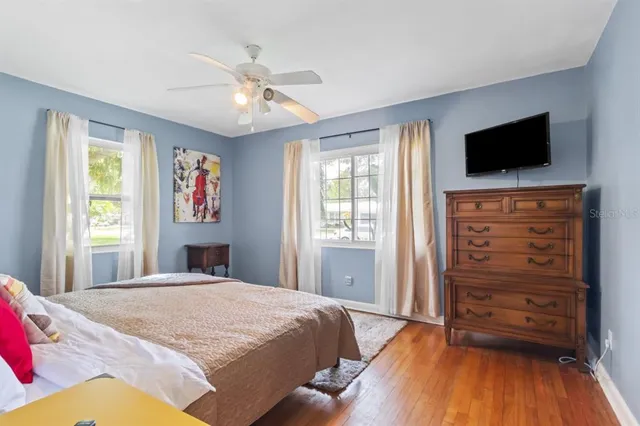 a bedroom with a bed and wooden floor