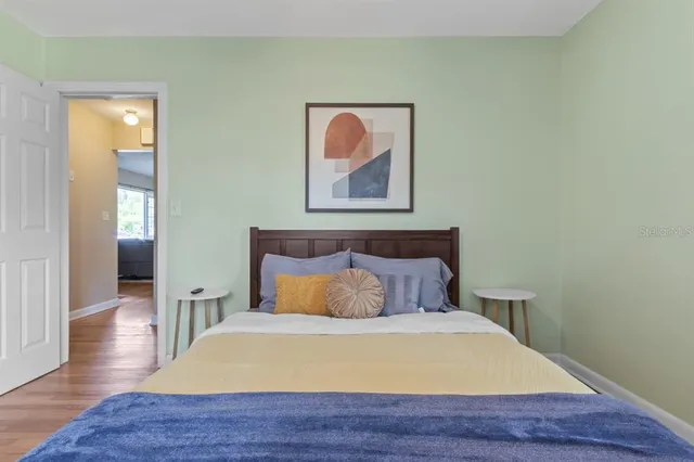 a bedroom with a bed and wooden floor