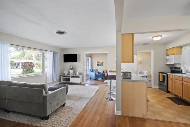 a living room with furniture flat screen tv and large windows