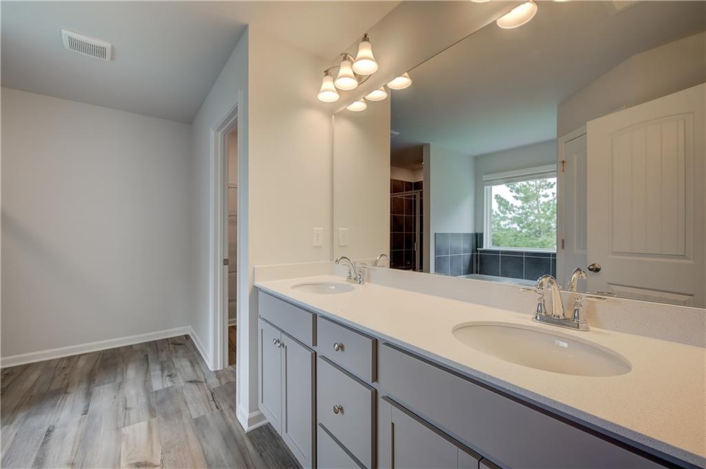 419993 St Anne's Place Covington, GA 30016 - Photo 25 of 30 a bathroom with a sink vanity granite and a mirror