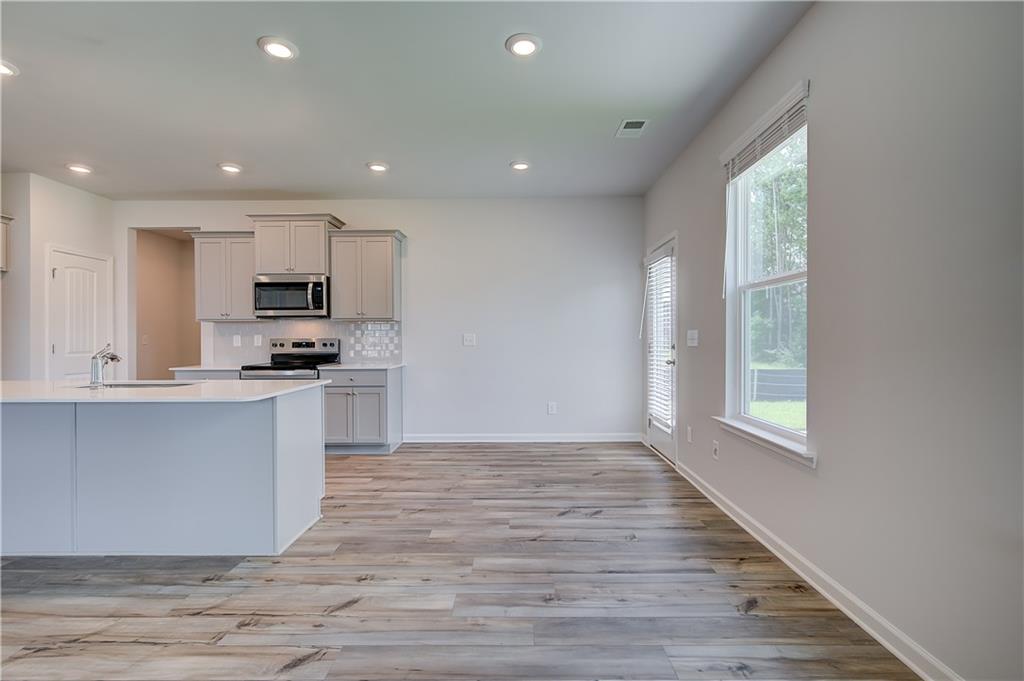419993 St Anne's Place Covington, GA 30016 - Photo 10 of 30 a large kitchen with hardwood floor and a window