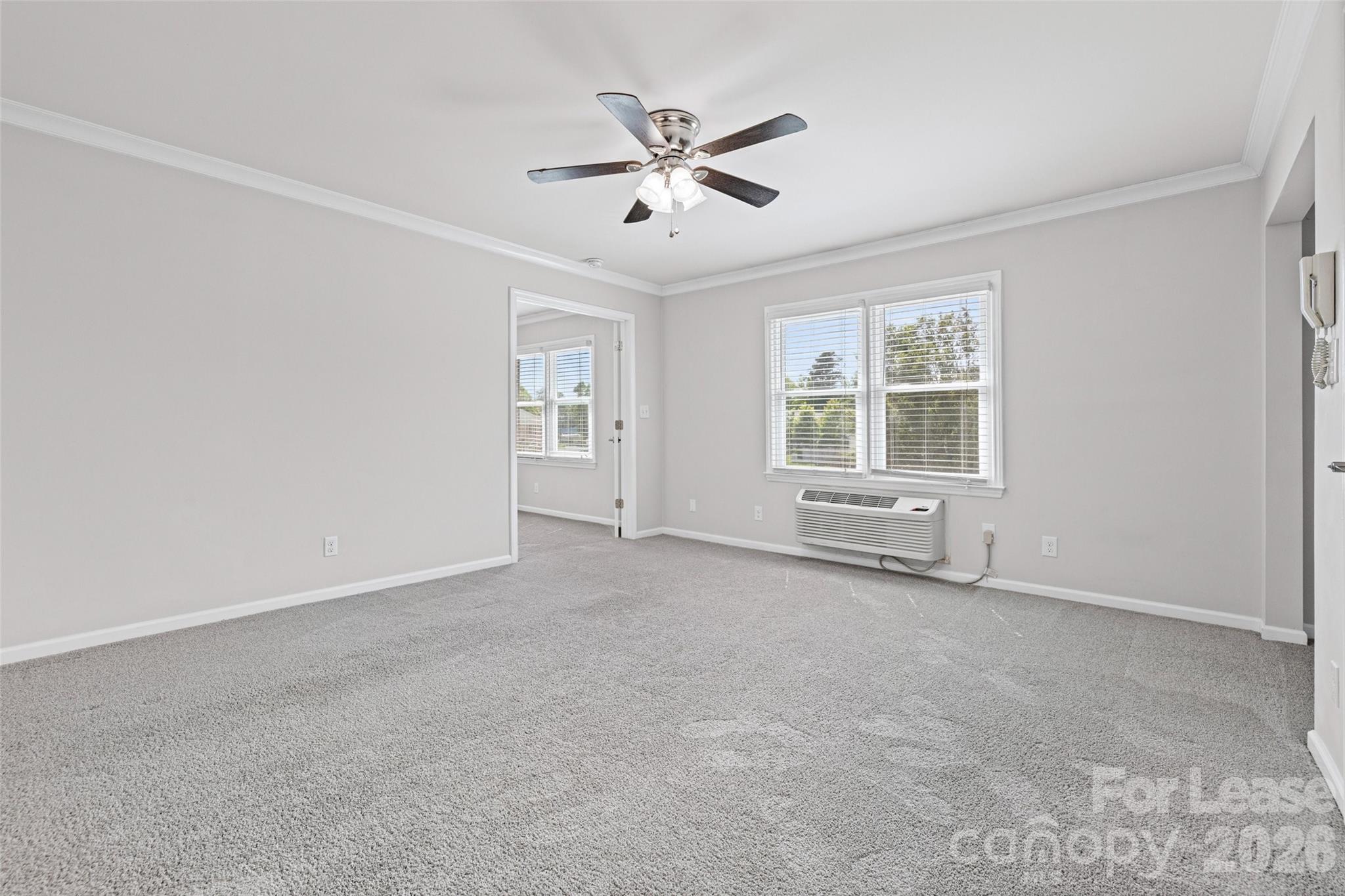 113 Stroupe Road, Unit E Gastonia, NC 28056 - Photo 5 of 33 an empty room with windows and ceiling fan