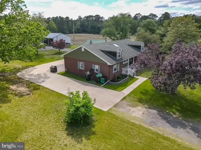 a view of a house with a yard and large tree