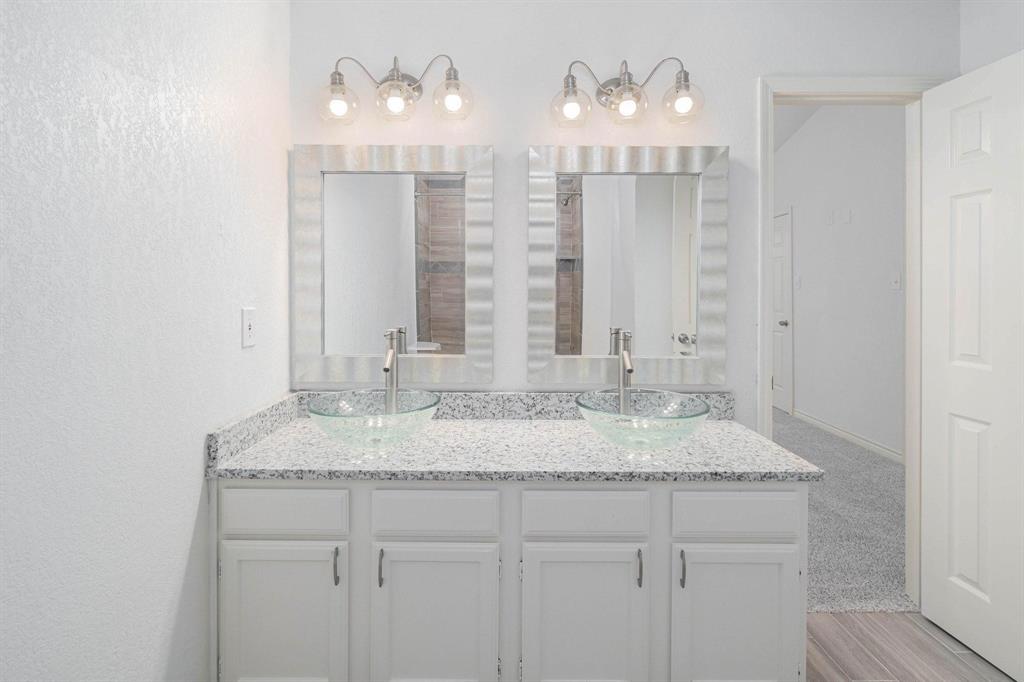 20 Abbey Road Euless, TX 76039 - Photo 5 of 8 Full bathroom with double vanity, a textured wall, and light colored carpet