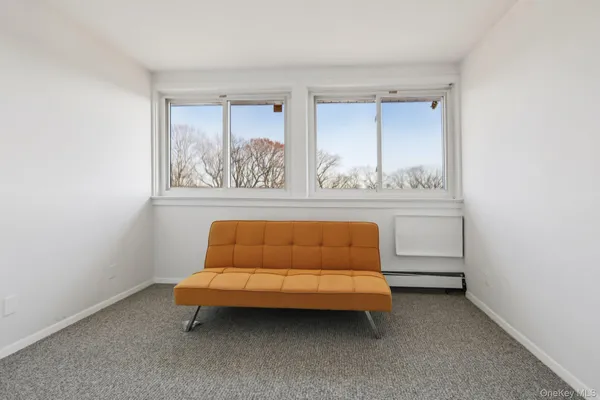 a blue couch sitting in a living room next to a window
