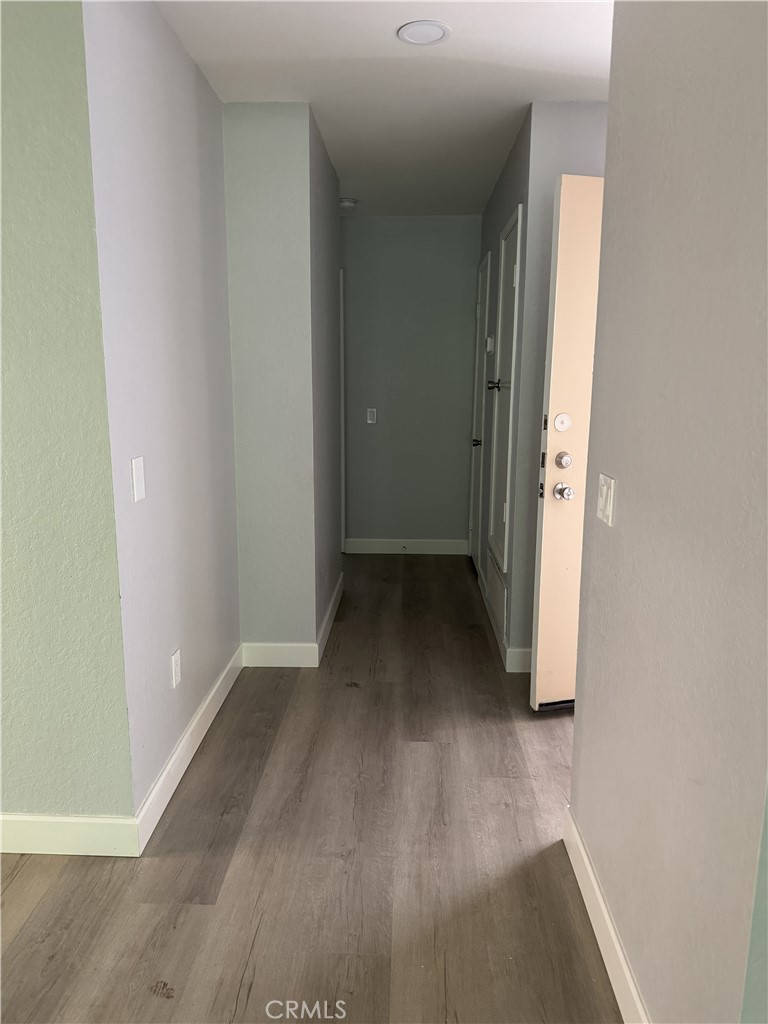 600 Central, Unit 332 Riverside, CA 92507 - Photo 14 of 31 an empty room with wooden floor and a hallway