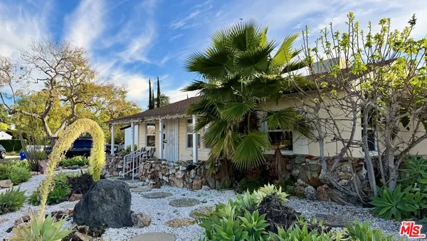 a couple of flower plants in front of house