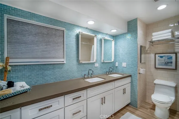 a bathroom with a granite countertop sink a toilet and mirror