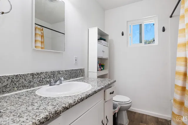 a bathroom with a granite countertop sink and a mirror