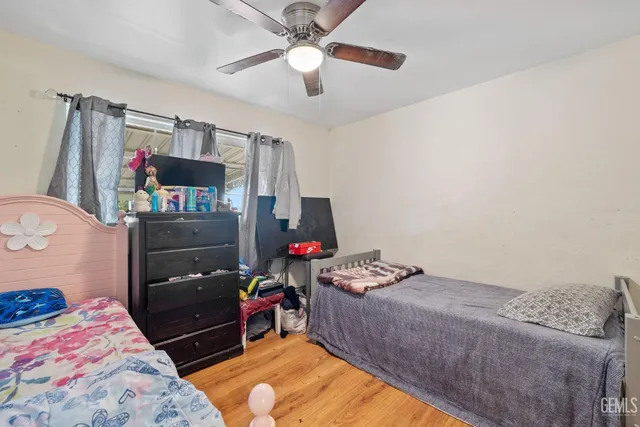 a bedroom with a bed and a flat tv screen on the dresser