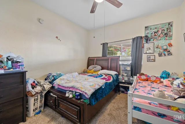 a bedroom with a bed a dresser and book shelf