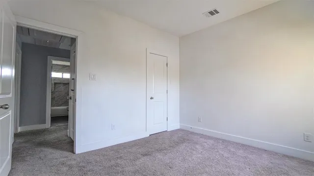 an empty room with closet and a bathroom