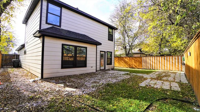 a view of a house with a small yard and wooden fence