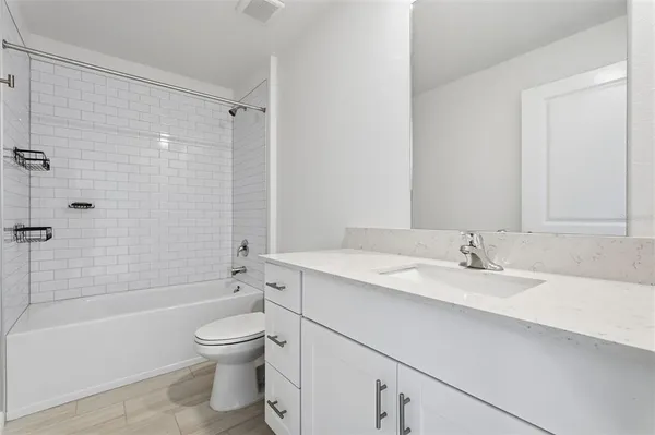 a bathroom with a granite countertop toilet a sink and a bathtub