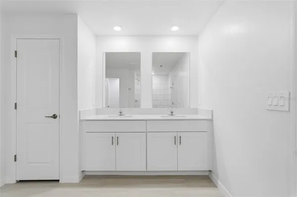 a bathroom with a double vanity sink and mirror