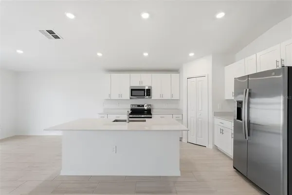 a kitchen with stainless steel appliances a refrigerator sink and microwave