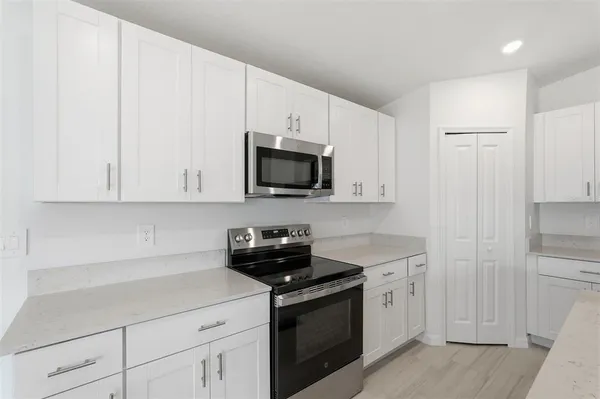a kitchen with white cabinets and stainless steel appliances
